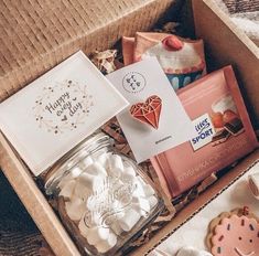 a box filled with cookies, marshmallows and other items that are on the table