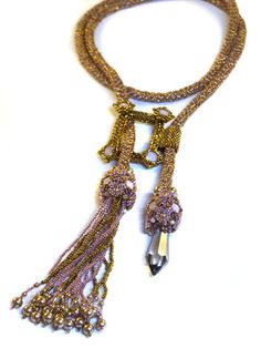 "My favorite element about making lariats is how versatile they are to wear. This lariat is no exception. On each end of a long netted chain, create two intricate ends sparkling with Swarovski chatons and embellished with pearls, adding fringe and a long chandelier point for two different designs. Stitch a \"frame\" like component with chatons on four corners as a focal point, that can be used in several different ways when wearing the lariat. Supplies Needed: 11/0 Seed Beads 11/0 Cylinder Beads Adjustable Beaded Lariat Necklace For Parties, Bohemian Lariat Necklace With Faceted Beads, Beaded Chain Lariat Necklace For Party, Adjustable Long Lariat Necklace With Faceted Beads, Adjustable Lariat Beaded Necklaces For Parties, Party Lariat Necklace With Beaded Chain, Bohemian Lariat Necklace With Beaded Chain, Bohemian Beaded Lariat Necklace, Bohemian Lariat Beaded Necklaces For Party