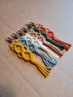 a bunch of different colored ropes on top of a cardboard box with one knot in the middle