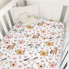 a baby crib with a blanket and stuffed animal on it's bedding