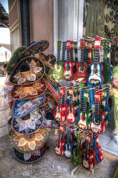 guitars and other musical instruments are on display in front of a store window, with a woman looking at them