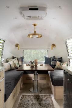 a kitchen area with a table and bench in the center, along with two windows