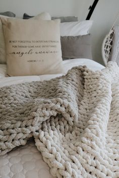 a white bed topped with a blanket and pillows