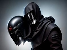 a person in a black outfit with a helmet on their head and hood over his face