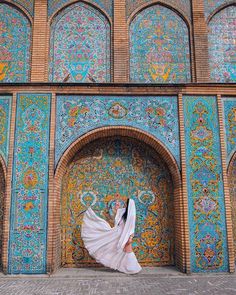 a woman standing in front of a colorful building