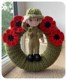 a crocheted wreath with a soldier holding flowers