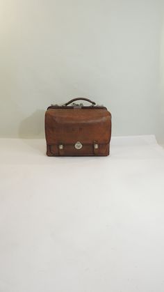 a brown suitcase sitting on top of a white table