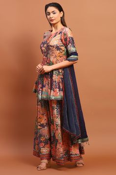 Navy blue peplum kurta with floral print and thread, sequin embroidery. Paired with flared pant and dupatta.
Components: 3
Pattern: Printed, Embroidery
Type Of Work: Floral, thread, sequin
Neckline: Round
Sleeve Type: Half
Fabric: Cotton Blend
Color: Blue
Other Details: 
Back deep V neck
Sequin lace embroidered border
Occasion: Sangeet - Aza Fashions Blue Bohemian Chanderi Palazzo Set, Blue Bohemian Set With Sheer Dupatta, Multicolor Sets With Sheer Dupatta, Traditional Blue Lehenga With Printed Motifs, Blue Floral Print Sets For Festivals, Blue Floral Print Festival Sets, Festive Blue Floral Print Sets, Blue Floral Chanderi Salwar Kameez, Semi-stitched Blue Floral Print Salwar Kameez