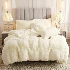 the bed is made with white fur and pillows