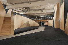 an empty room with wooden walls and black carpet on the floor, as well as stairs