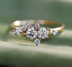 a diamond ring sitting on top of a green leaf