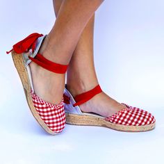 Step into summer with these stylish Red Gingham Flat Espadrilles with Leather Heel for Women. The classic canvas espadrille design is elevated with a bold red and white checkered print, adding a touch of playful charm to any outfit. The silver leather heel provides a modern twist, offering both style and comfort all day long. Whether you're strolling through the city streets or relaxing on a seaside vacation, these flats are the perfect accessory to complete your look. Treat yourself to these fashionable espadrilles and step out in style this season. These canvas espadrilles lined with cotton fabric are tied with a soft red cotton ribbon. The 3 cm wedge made of natural jute braid and the padded leather insole make them extremely comfortable. The jute sole is finished with a rubber layer. Casual Round Toe Sandals For Picnic, Summer Round Toe Sandals For Picnic, Red Closed Toe Espadrilles For Spring, Red Flat Espadrilles For Summer, Spring Slip-on Espadrilles With Red Sole, Red Round Toe Espadrilles For Summer, Closed Toe Espadrilles With Red Sole, Red Espadrilles With Rubber Sole For Spring, Red Closed Toe Espadrilles