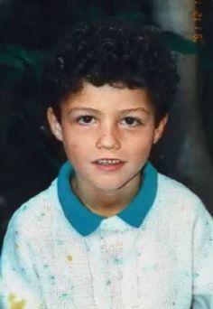 a young boy wearing a blue collared shirt