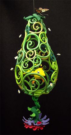 a painting of a green pear with swirls and butterflies on it's top