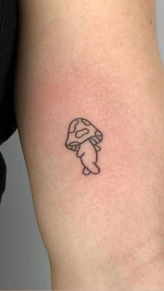 a person with a small tattoo on their arm that has an image of a mushroom