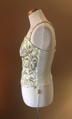 "Beautiful and unusual camisole accented with metallic floral appliqués. The top is made of nylon and Lycra for a slimming effect. Staves are added for a mild support and to maintain a slimming look. Top can be worn with jeans as well as slacks or skirt. Measures 16\" from armpit to armpit 10.5\" from armpit to hem 13\" across the waist This top has a lot of stretch!" Boned Bodice Top For Spring Night Out, Boned Bodice Tops For Night Out In Spring, Fitted Embellished Sleeveless Camisole, Embellished Fitted Sleeveless Camisole, Spring Tops With Stretch Boned Bodice, Spring Stretch Tops With Boned Bodice, Glamorous Fitted Camisole Top, Spring Tops With Stretch And Boned Bodice, Fitted Tank Top For Party