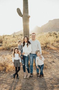 a family standing in front of a saguado cactus