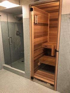 an empty sauna in a bathroom with tiled walls