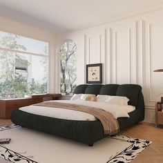 a large bed sitting in the middle of a living room next to a tall window