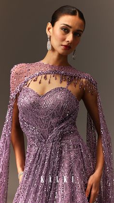 A lilac, adorned with shimmering sequins that dance in the light.
It's a vision of ethereal beauty, with cape like sleeves that gracefully frame the shoulders.
The neckline a cheeta patterned fabric.
Tassels, like delicate tendrils, adorn the neck, adding a playful touch.
The gown drapes effortlessly, creating a cascade of shimmering fabric that flows into a cape style train.
The sweetheart neckline of the blouse adds a hint of femininity.
Perfect for special occasions. Fabric Tassels, Cape Style, Cape Sleeves, Sequin Gown, Ethereal Beauty, Patterned Fabric, Sweetheart Neckline, Fabric Patterns, Cape