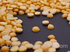 some yellow and white beans are on a black surface with the word love written in it