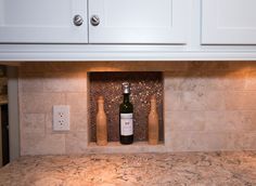 a bottle of wine sitting on top of a counter next to two corkscrew bottles