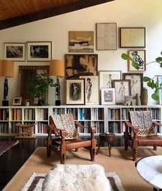 a living room filled with lots of furniture and pictures on the wall above it's bookshelf