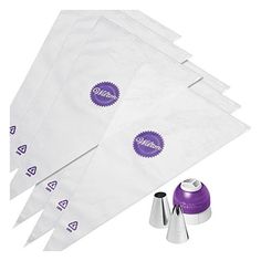 six white bags with purple stickers on them next to some silver cups and cones