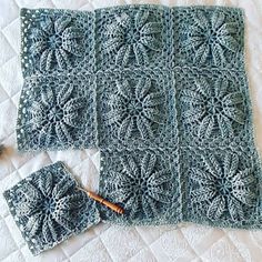 a crocheted blanket and matching potholders on a bed