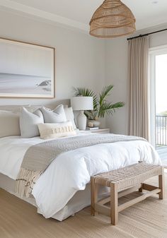 a bed with white sheets and pillows in a bedroom next to a large sliding glass door