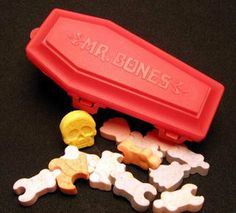 a red box with bones and bones in it sitting on a black surface next to other bone bones