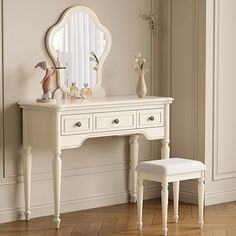 a white dressing table with a stool and mirror on it's side in a room