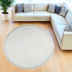 a living room with white couches and pillows on top of the wooden flooring