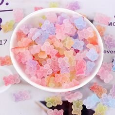 a bowl full of gummy bears sitting on top of a table next to a measuring scale