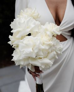 a woman holding a bouquet of white flowers