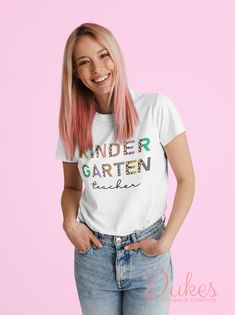 a woman with pink hair wearing a t - shirt that says kinder garten