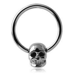 a silver skull ring with black eyes on the front and back ends, is shown