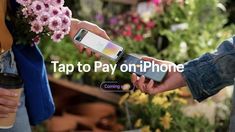 two people exchanging their cell phones with flowers in the background and text that reads tap to pay on iphone