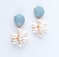 two pairs of blue and white earrings with pearls on them, sitting next to each other