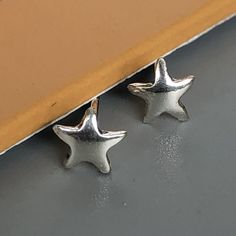 A PAIR of tiny sterling silver star ear studs. Size: 5 x 5 mm. Weight: 0.46gm Price listed is for a PAIR of studs. These earrings are made of 925 hypoallergenic sterling silver Can be packaged in a gift box. I can include a personal message from you if needed You are welcome to contact me at... bhavnakwintra1956@gmail.com For more beautiful pieces from my shop, please browse 👇 TOE RINGS: https://www.etsy.com/your/shops/TheSilverGame/tools/listings/section:27020628,view:table EAR HOOPS: https:// Nickel-free Star-shaped Silver Piercings, Minimalist Silver Star Piercings, Nickel Free Silver Star-shaped Piercing, Nickel-free Silver Star Piercings, Sterling Silver Star-shaped Piercings, Silver Star-shaped Sterling Silver Piercings, Sterling Silver Star Piercings In Silver, Nickel Free Star Shaped Silver Cartilage Earrings, Silver Star-shaped Internally Threaded Piercings