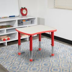 a child's table with red legs and a clock on the wall behind it