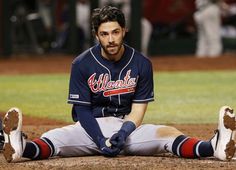 a baseball player sitting on the ground during a game