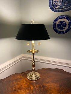 a table with a lamp and plates on the wall