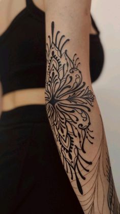 a woman's arm with a tattoo design on the left side of her arm