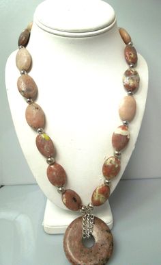 For sale: (1) s108 Genuine Rhodonite Necklace Sterling Silver Lock Donut Pendant Necklace 24"   PLEASE READ ENTIRE DESCRIPTION BEFORE PURCHASING   Pre-owned item. Good condition.    An eye catching necklace which will look fabulous among ladies of all age group.  This gorgeous rhodonite necklace has some beautiful shades of pink, brown, black & grey. I just love the uniqueness of rhodonite with it's beautiful striations. This necklace measures approx. 24" in length , and the extender  is another 3" in length.  The donut is large at 2" round.  Between each gemstone are 6mm sterling silver balls. Sterling silver lobster claw closure    *This picture displays the exact item that you will receive. We do our best to show everything in the pictures.   -------------------------------------------- Handmade Oval Jasper Necklaces, Handmade Jasper Oval Necklaces, Handmade Round Jasper Necklaces, Handmade Jasper Round Necklaces, Handmade Jasper Oval Necklace, Handmade Oval Jasper Necklace, Round Jasper Gemstone Jewelry, Oval Hand-strung Jewelry As A Gift, Round Jasper Jewelry For Healing