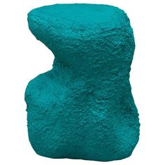 a blue rock sitting on top of a white surface