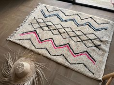 a rug on the floor next to a straw hat