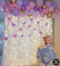 a room decorated with balloons, lights and a princess sitting on a chair in front of a curtain