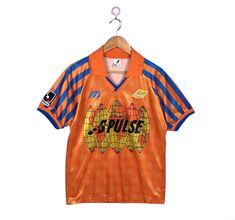 an orange and blue soccer jersey hanging on a hanger