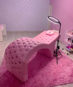 a pink bed sitting on top of a rug in a bedroom next to a mirror